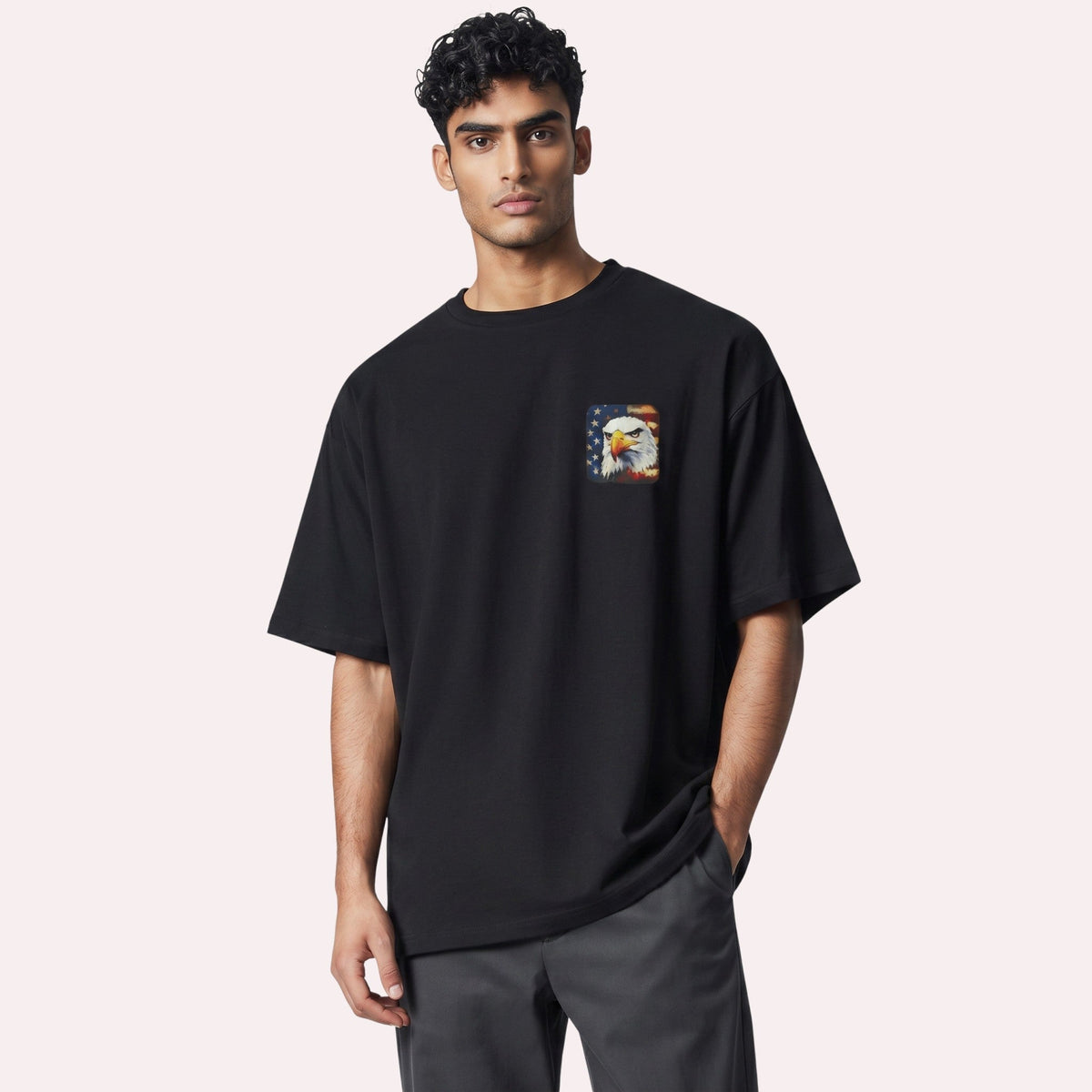  black cotton graphic tee featuring a small bald eagle and American flag chest print on a male model