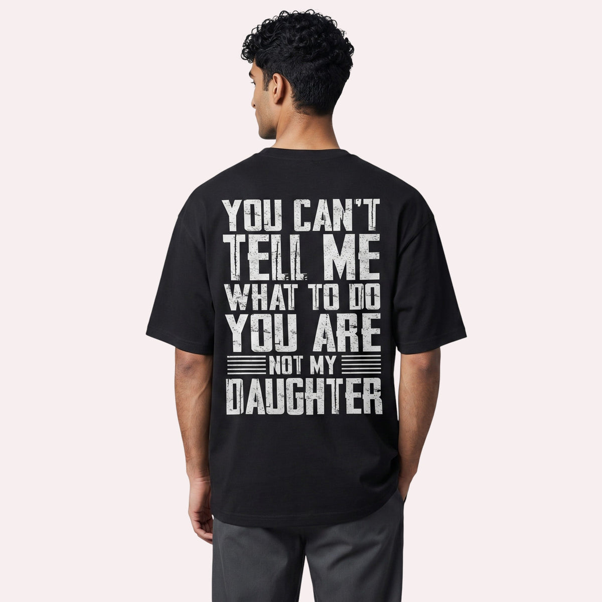  black cotton graphic t-shirt with distressed white typography on the back, worn by a man.