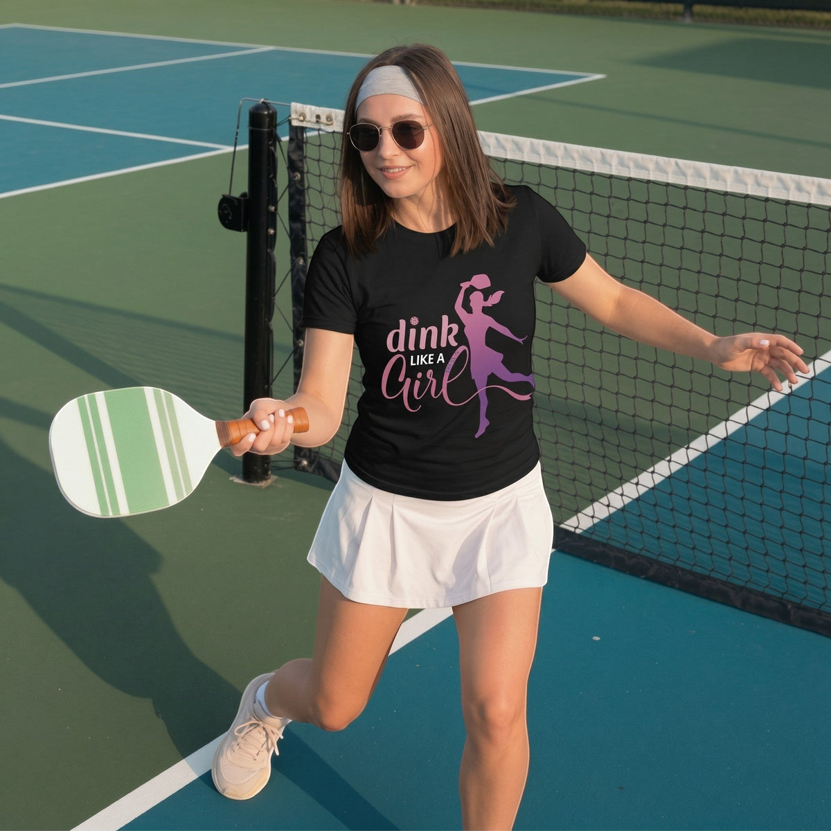  black cotton t-shirt with Dink Like a Girl pickleball graphic worn by a woman on a pickleball court