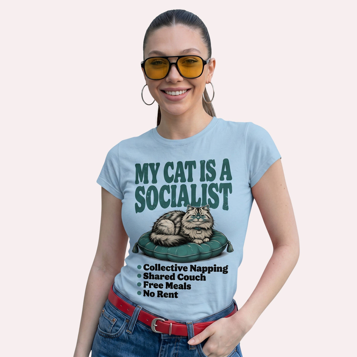  light blue cotton graphic tee featuring a cat illustration and My Cat Is a Socialist text on a woman