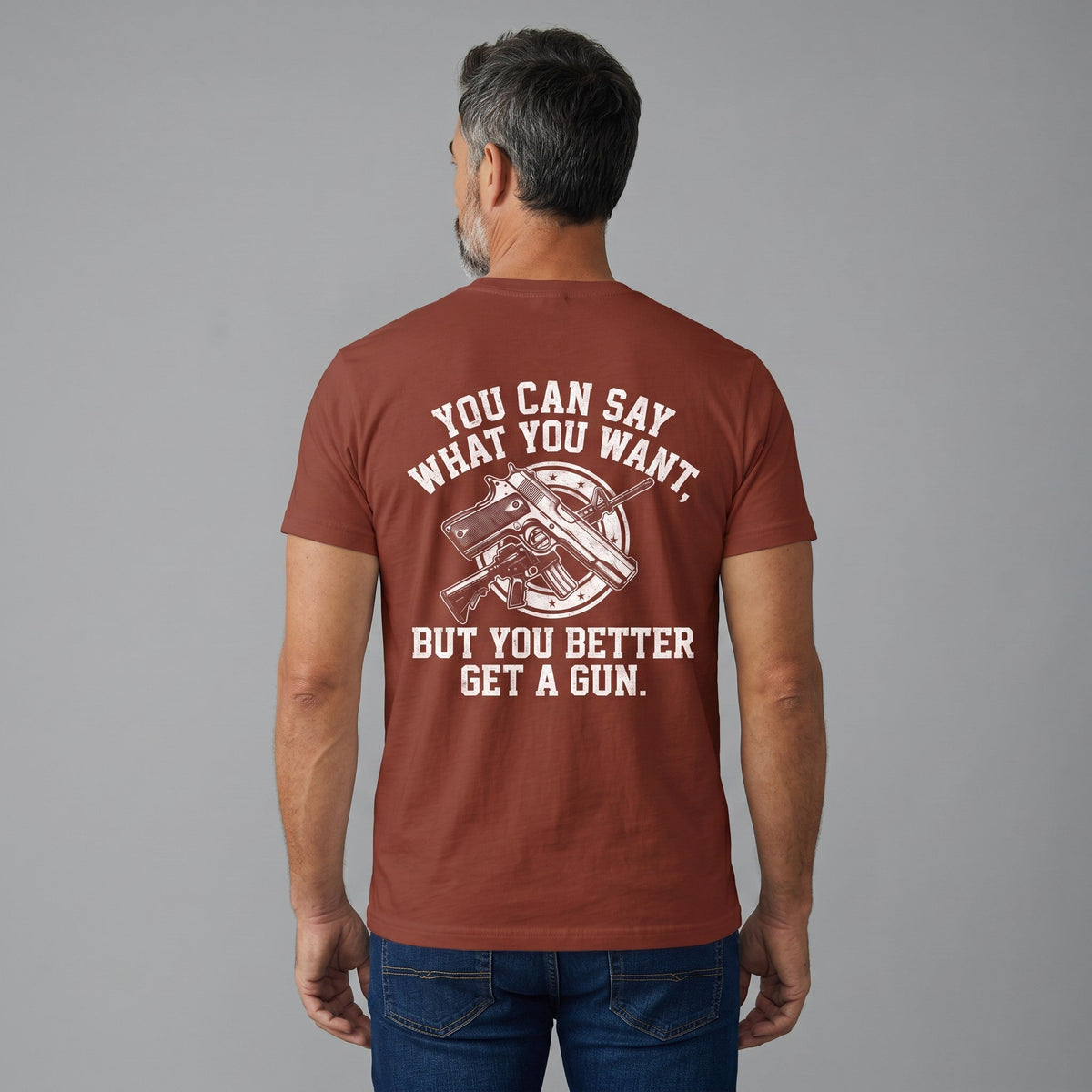  rust-colored cotton t-shirt with white graphic print featuring a gun and bold text on the back