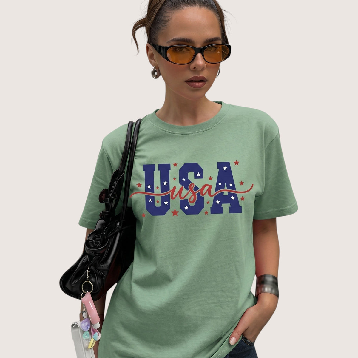  sage green unisex cotton t-shirt with USA patriotic graphic print worn by a woman with sunglasses