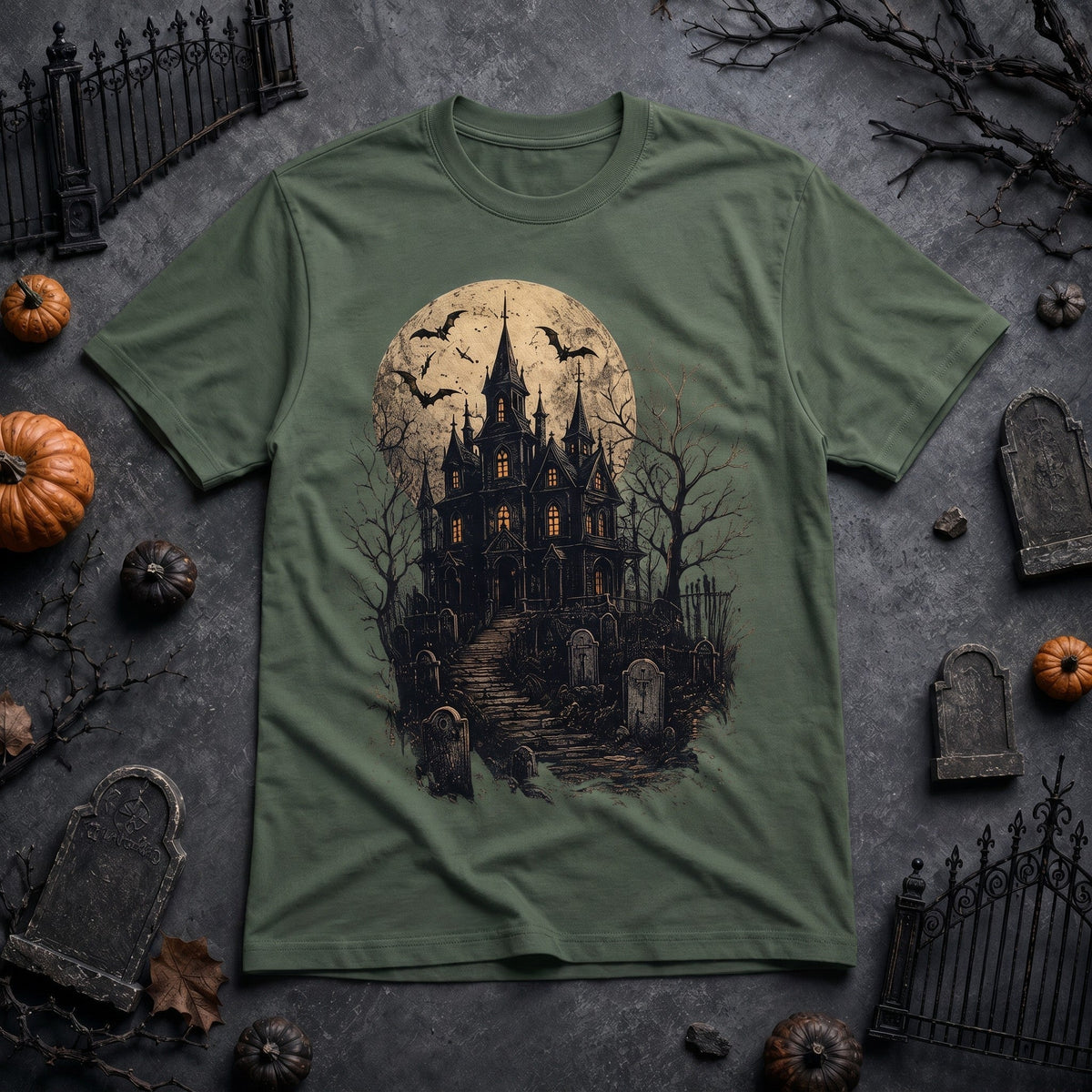  olive green crew neck t-shirt featuring a spooky haunted house, graveyard, and full moon graphic.