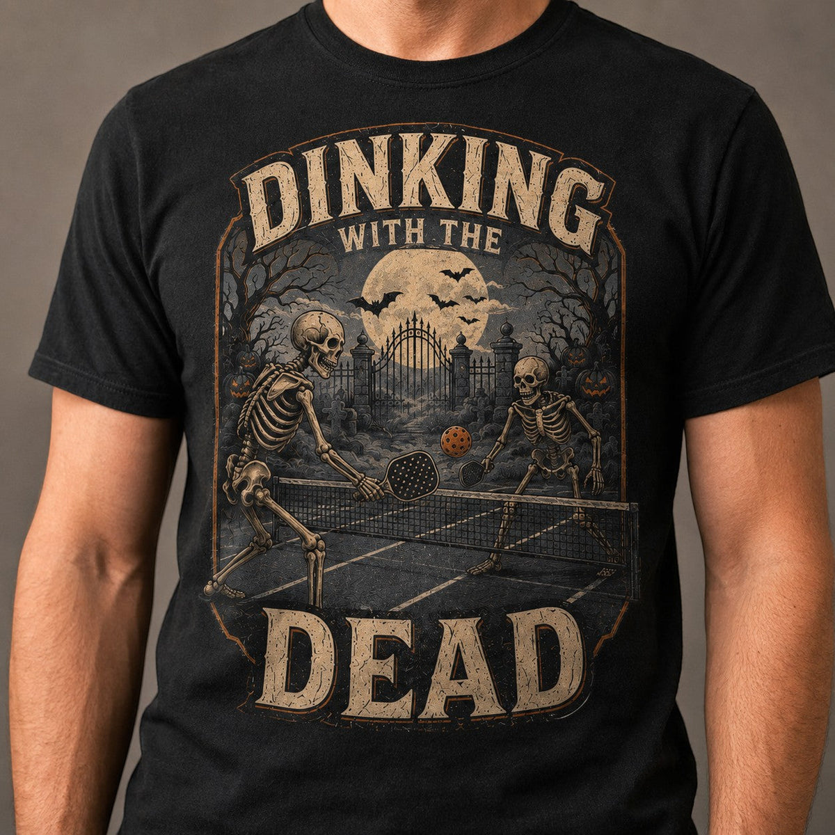  black cotton t-shirt featuring a vintage skeleton pickleball graphic with a spooky Halloween theme.